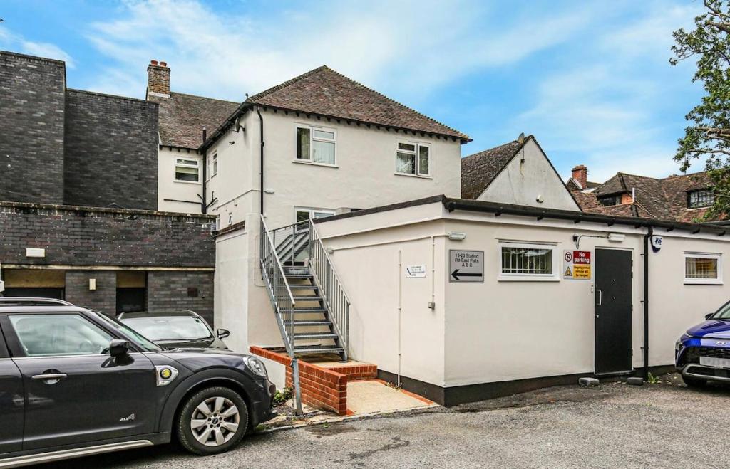 The OXTED high street studio في Titsey: سيارة متوقفة أمام البيت الأبيض