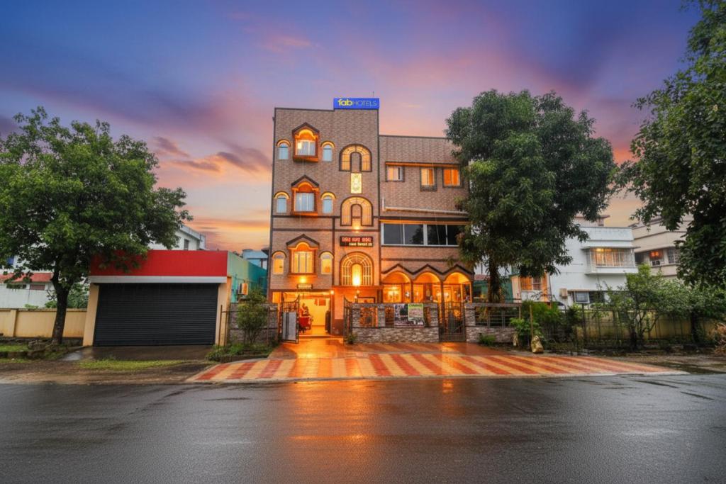 杜尔加布尔FabHotel Sriya - City Center, Durgapur的一座大建筑,背景是日落