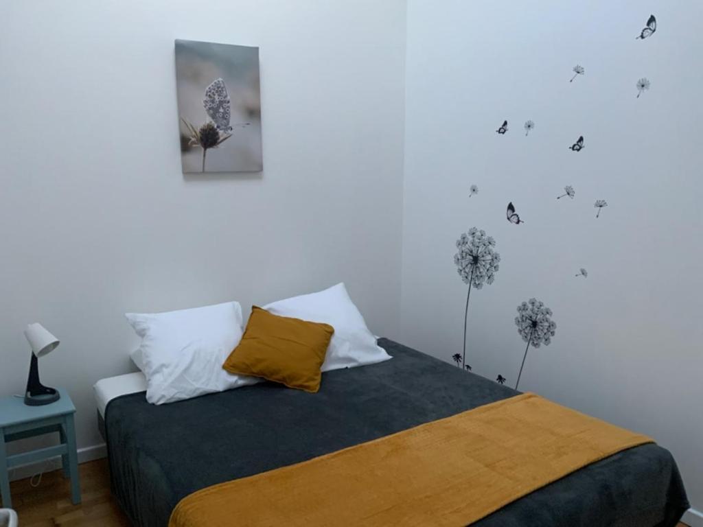 滨海布雷蒂尼奥勒Maison de bourg cosy et fonctionnelle proche mer的卧室里有一张床，墙上挂着一幅画