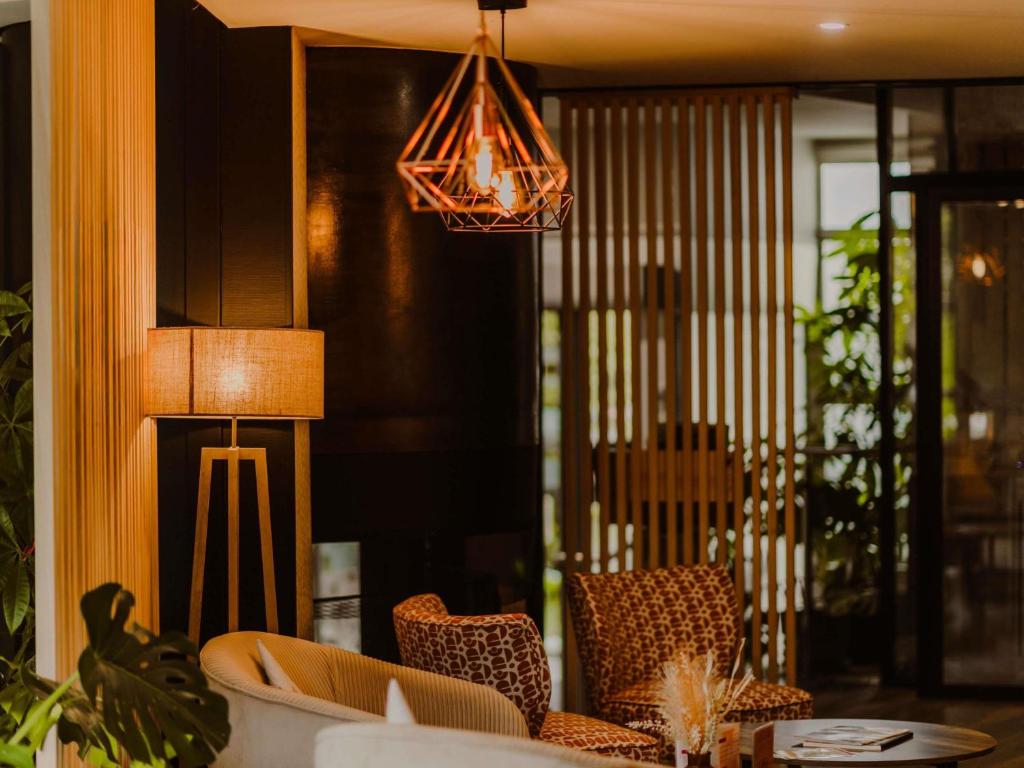 una sala da pranzo con tavolo, sedie e luci di Mercure Annecy Sud ad Annecy