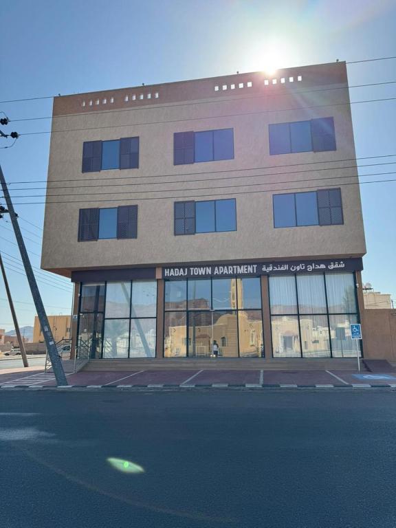 un edificio con muchas ventanas a una calle en شقق مفروشة هداج تاون العلا, en Al Ula