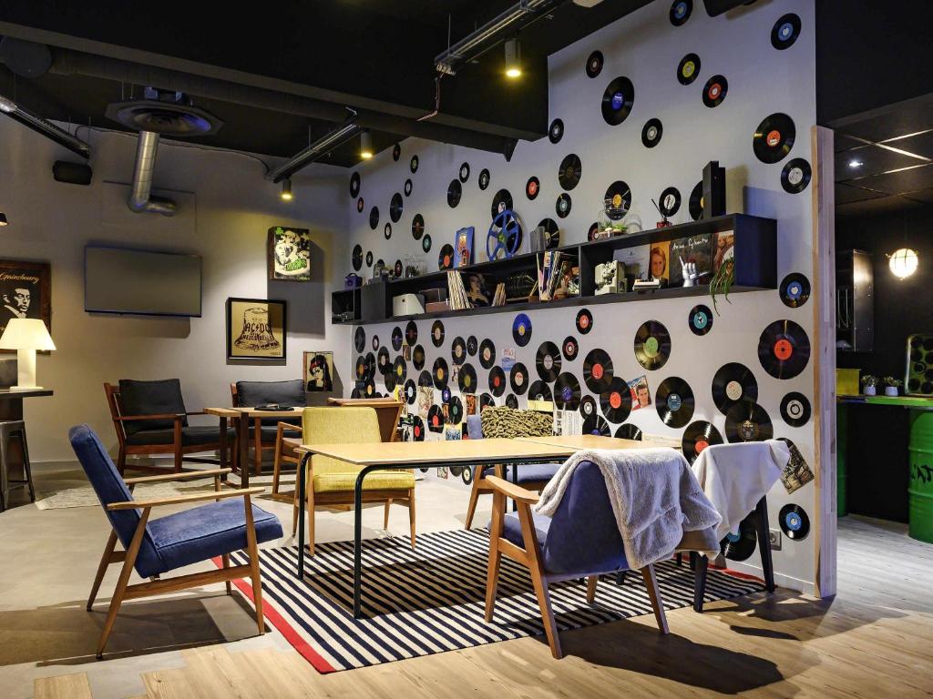 兰斯兰斯展览中心美居酒店的配有桌椅的房间和带板的墙壁