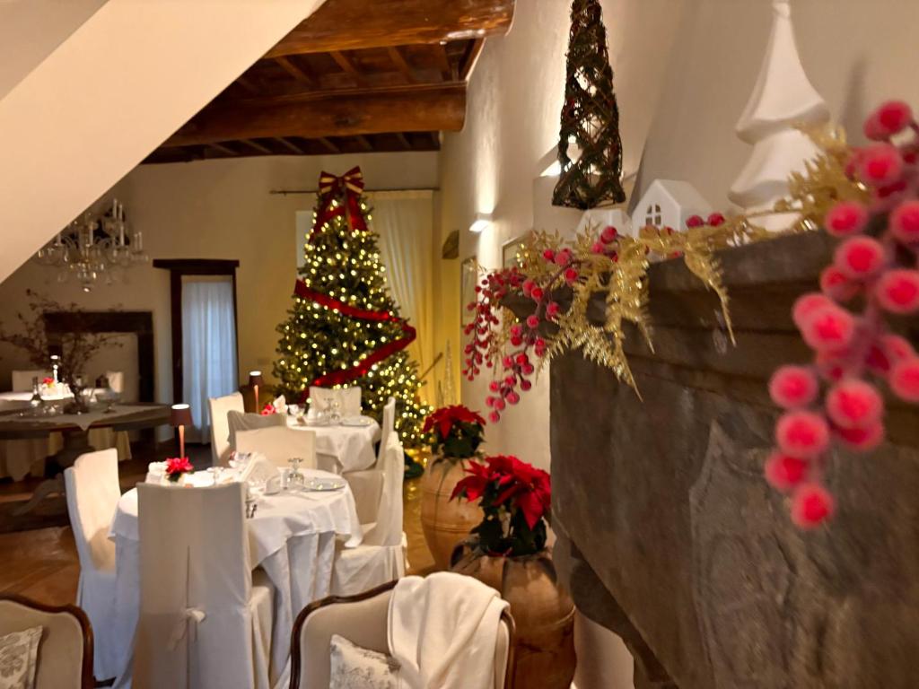 Un comedor con árbol de navidad y mesas blancas. en L'Archetto Dimora Storica, en Viterbo