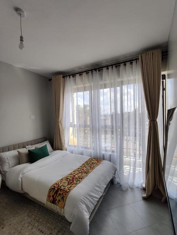 a bedroom with a large bed and a large window at Solara Loft in Nairobi