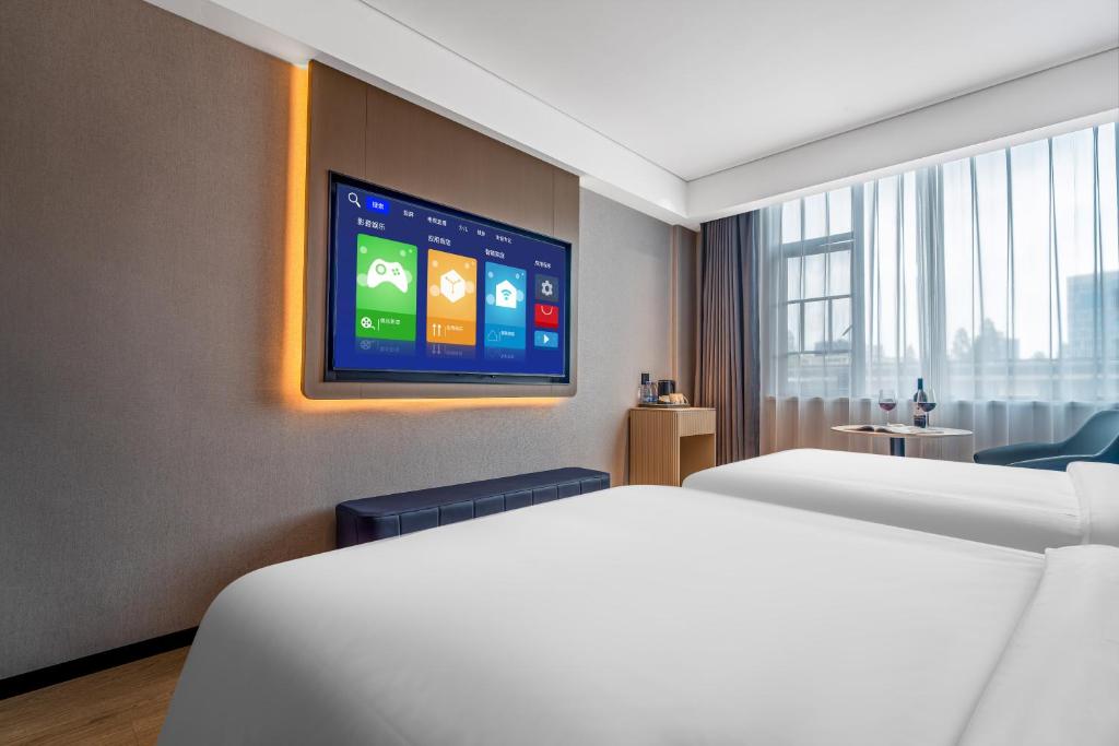 Postel nebo postele na pokoji v ubytování Huanman Hotel Hengyang Jiefang Road Lianhu Square Branch