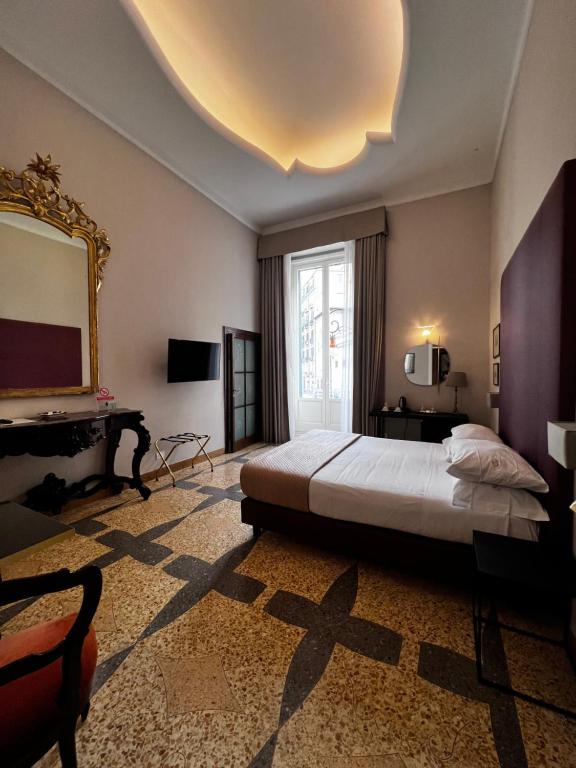 een slaapkamer met een groot bed en een spiegel bij Dimora Donna Elena in Napels