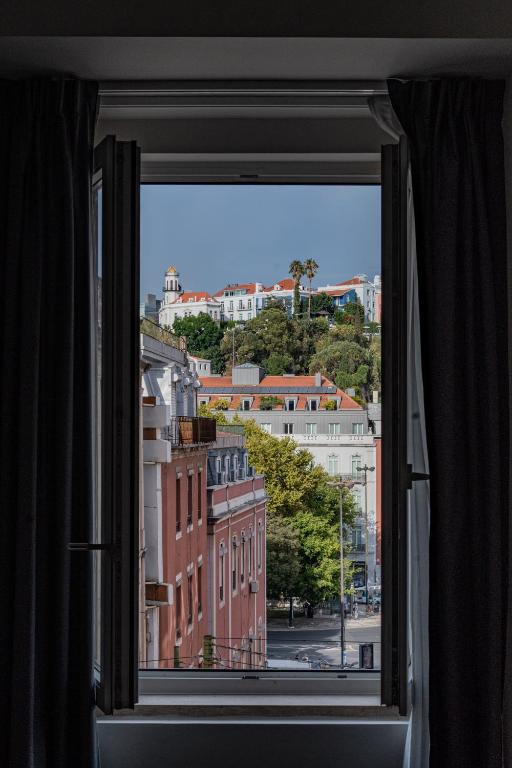 a window with a view of a city at Glória Suites Hotel by Succeed in Lisbon