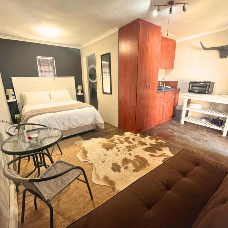 a bedroom with a bed and a table and a couch at Helpmekaar in Wellington