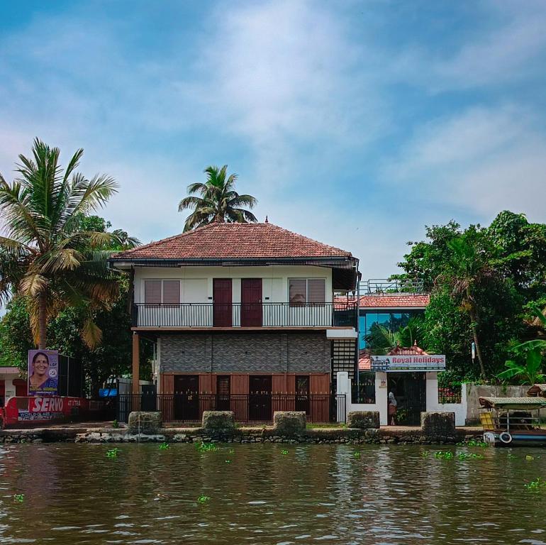 a house on the water next to a river at Royal Holidays in Alleppey