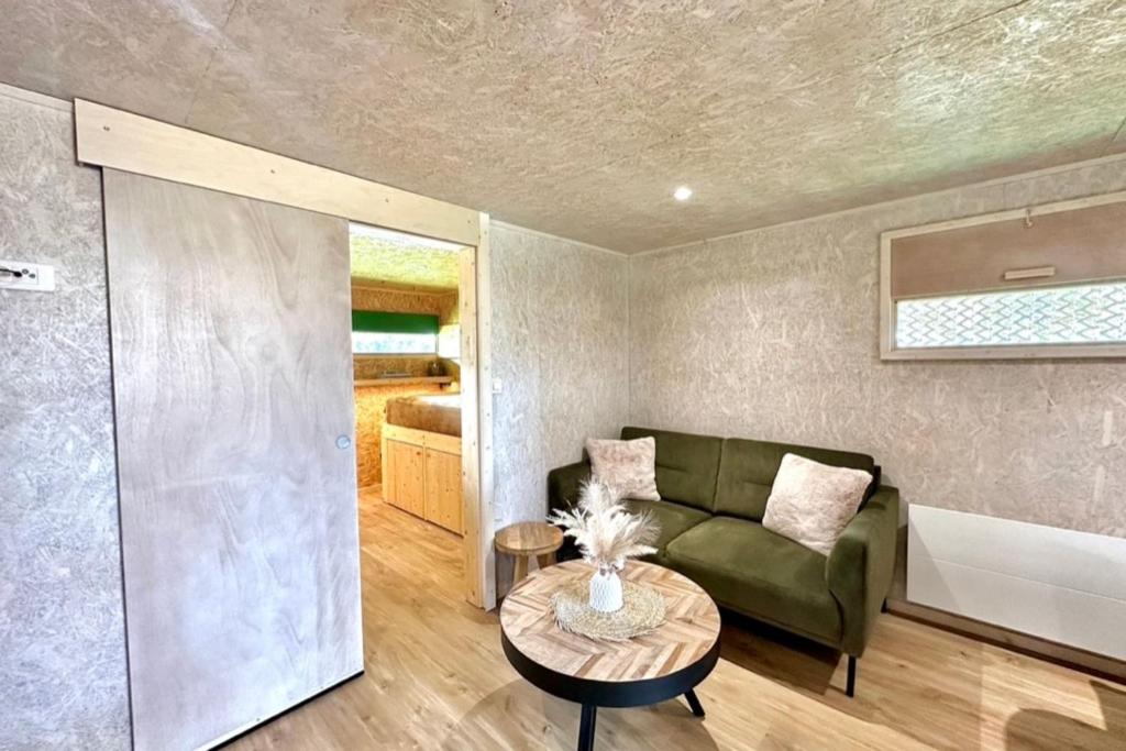 ein Wohnzimmer mit Sofa und Tisch in der Unterkunft Les 1000 Ailes-Expérience Unique dans une Hutte in Le Crotoy