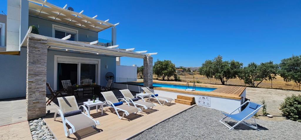 a house with chairs and a swimming pool at Gennadi Villa Mary in Gennadi