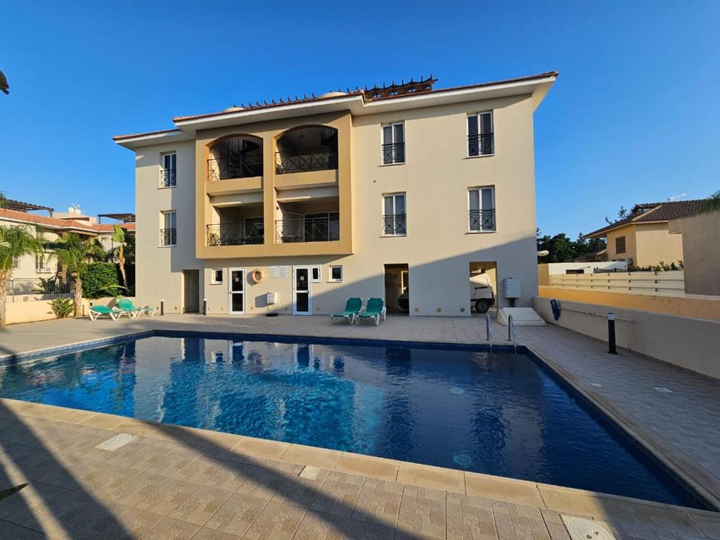 ein Gebäude mit einem Swimmingpool vor einem Gebäude in der Unterkunft Horizon View 2 in Kiti