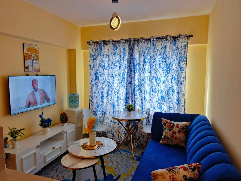 基苏木Makasembo Estate的客厅里有一张蓝色沙发和一台电视