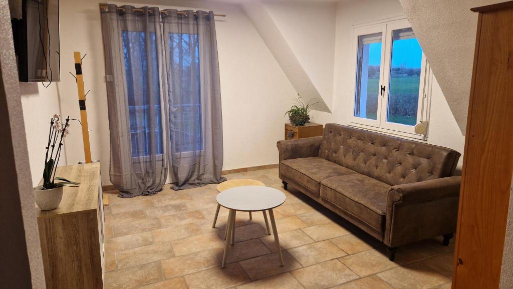 a living room with a couch and a table at Eeckhoutveld Hébergement 3 chambres in Merckeghem