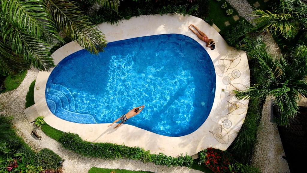 圣塔特蕾莎海滩Outsite Santa Teresa Playa的游泳池的顶部景色,其中有2人