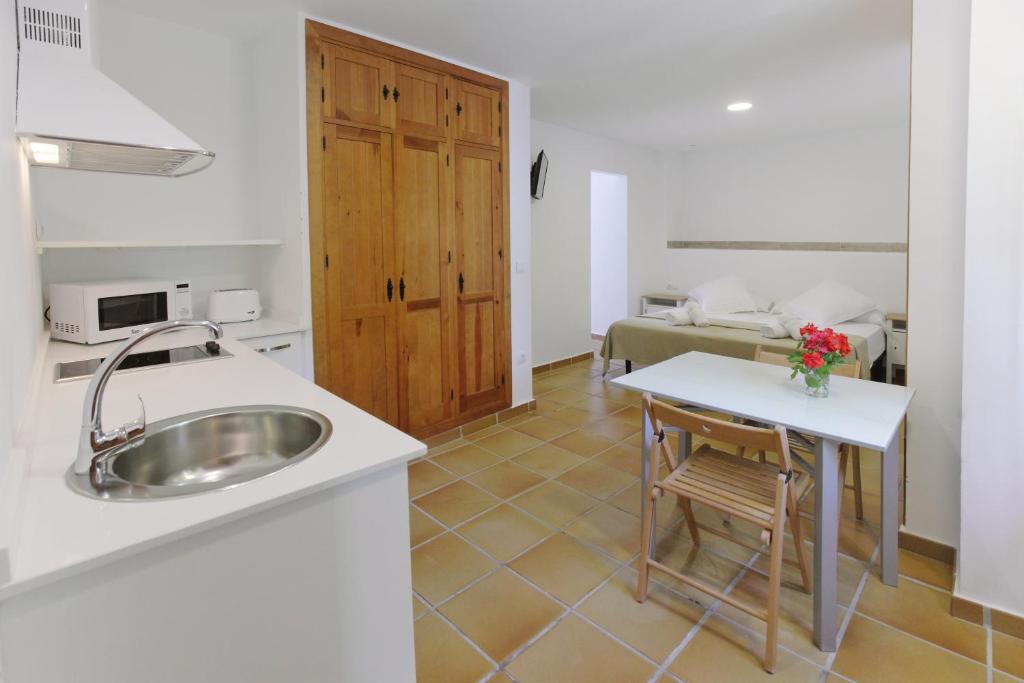 a kitchen with a sink and a table at Apartamentos Gravina in Tarifa