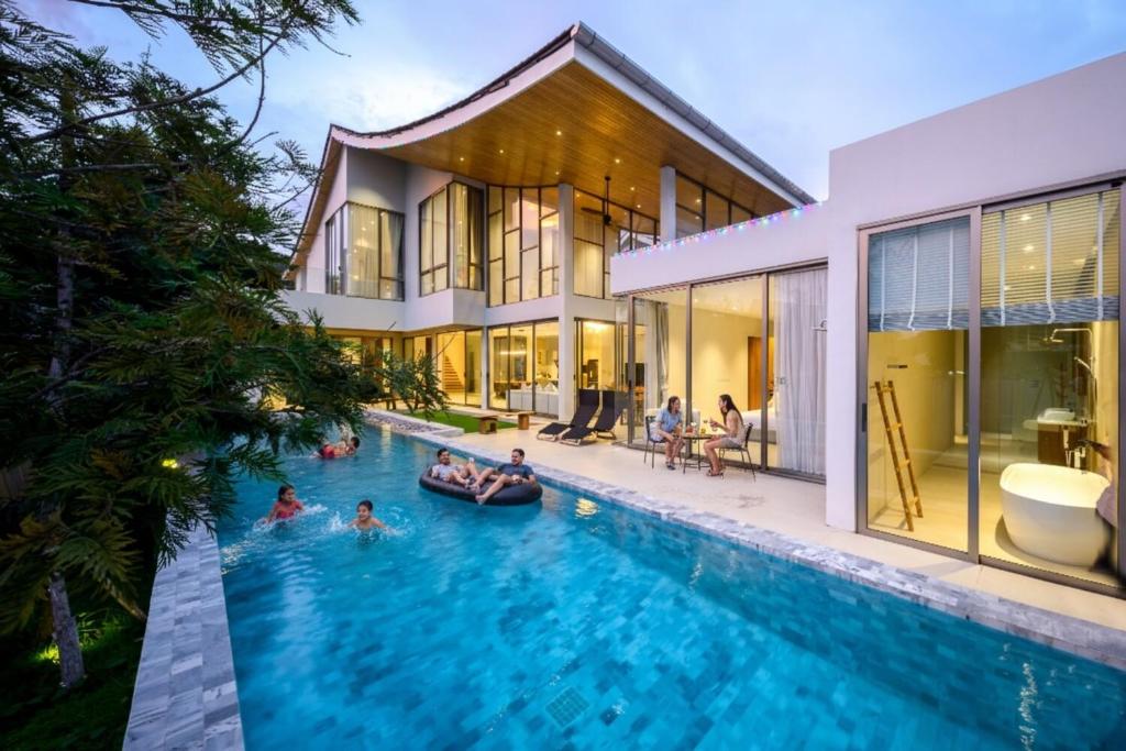 a group of people in the swimming pool of a house at Brand-New & Luxury 5BR Pool Villa Trinity C2 in Ban Pak Lak