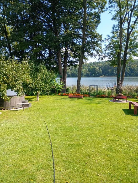 a park with benches and a view of a lake at Mrągowo Pokoje nad jeziorem i Apartament rodzinny in Mrągowo