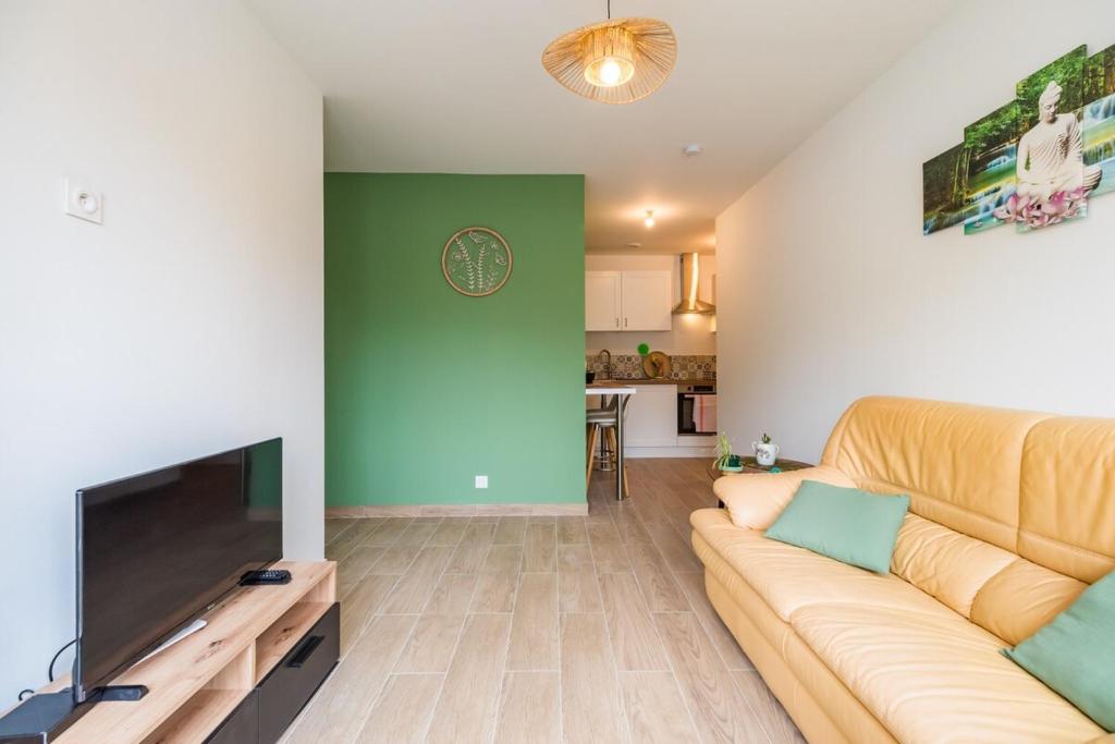 a living room with a couch and a flat screen tv at Le T2 Zen de Guingamp confort au coeur de la ville in Guingamp