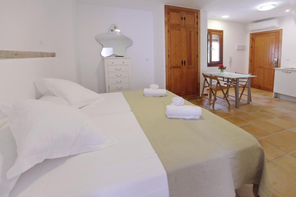 a bedroom with a large white bed and a table at Apartamentos Gravina in Tarifa