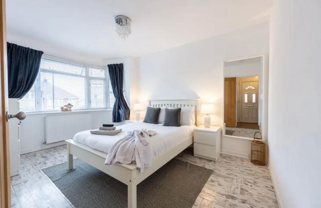 a white bedroom with a large bed and a bathroom at Peaceful location with FREE parking for 2 cars - hosts up to 4- business or leisure stays, inc hot-tub-Netflix-complimentary breakfast in Southampton