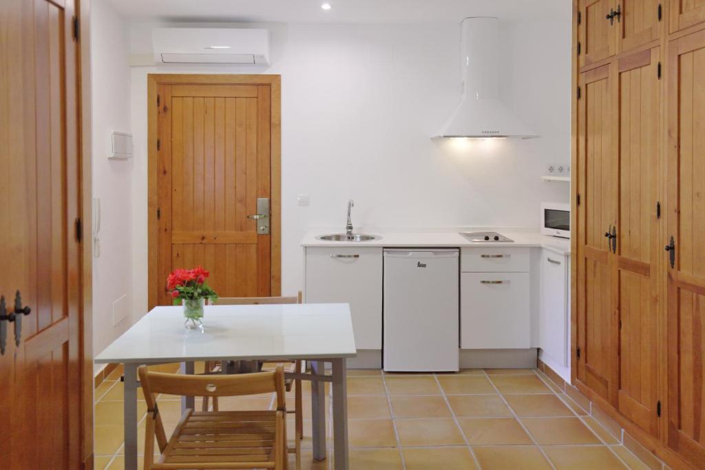 a kitchen with white appliances and a table and chairs at Apartamentos Gravina in Tarifa