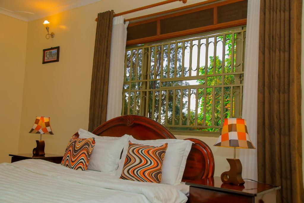 a bedroom with a bed and a large window at Calm Suites Kampala in Kampala