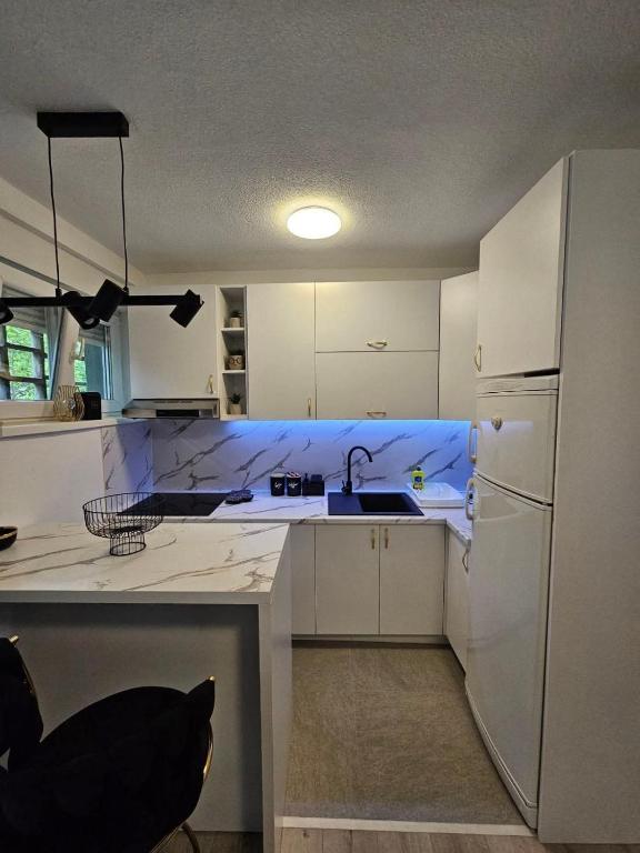 a kitchen with a sink and a refrigerator at City Center Luxury Apartment in Mostar