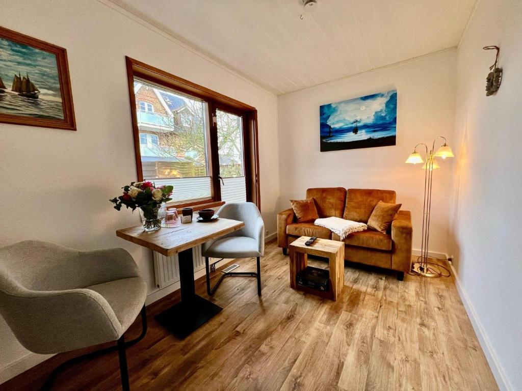 韦斯特兰Kapitaenshaus-Lassen-Zimmer-Nes-Puek的客厅里有一张沙发和一张桌子。