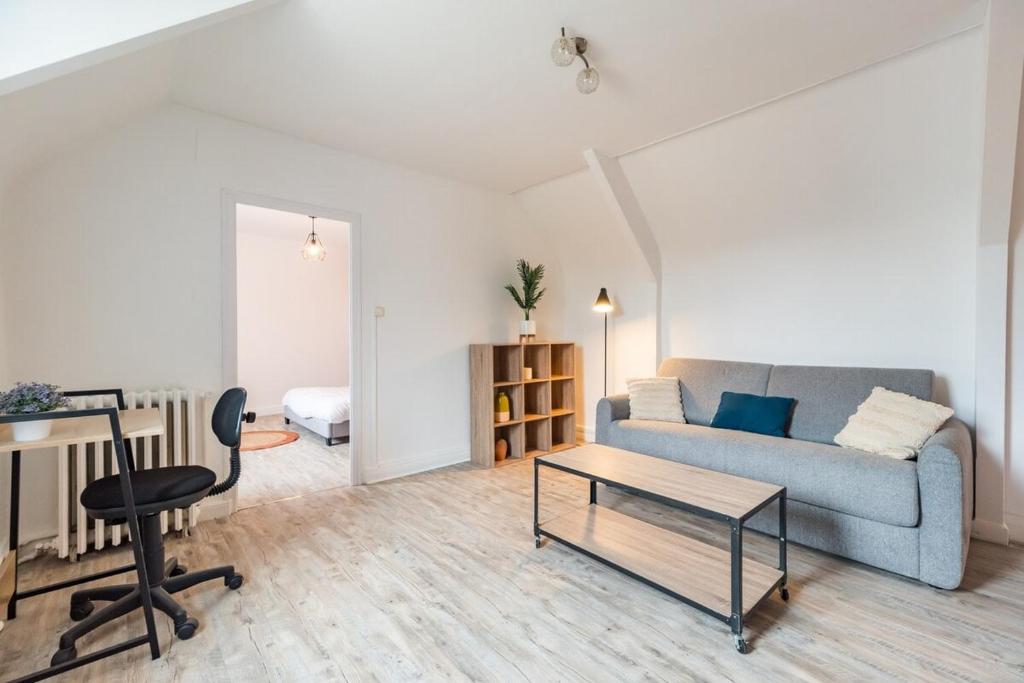 a living room with a couch and a table at Maison Confortable au coeur de Guingamp in Guingamp