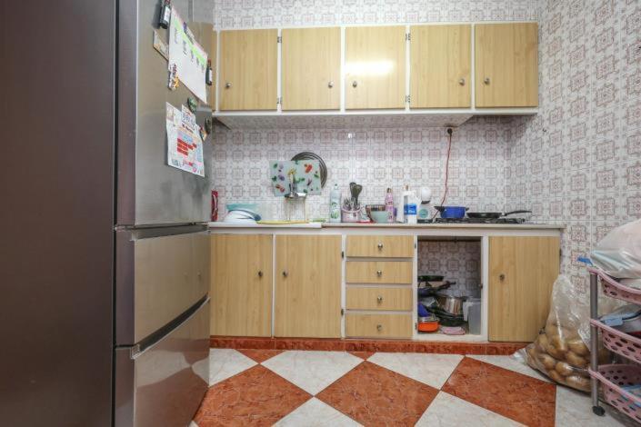 a kitchen with wooden cabinets and a refrigerator at Tropical Elegance in central Panglao ! in Panglao