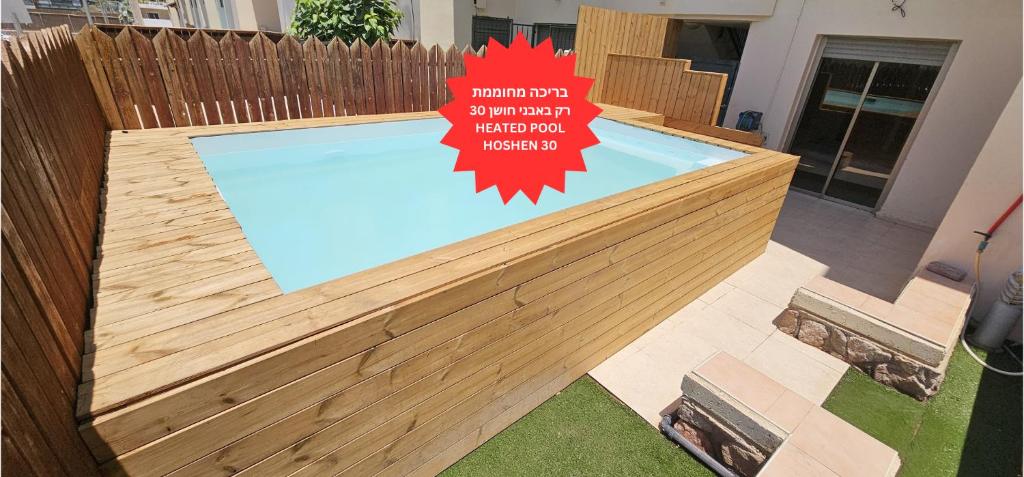 شقق عطلات أمدار في إيلات: مسبح بسياج خشبي مع لافته