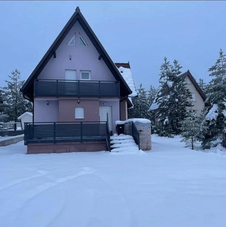 ein Haus mit schwarzem Dach im Schnee in der Unterkunft Blidinje S7 - Risovac -280 m staza in Jablanica
