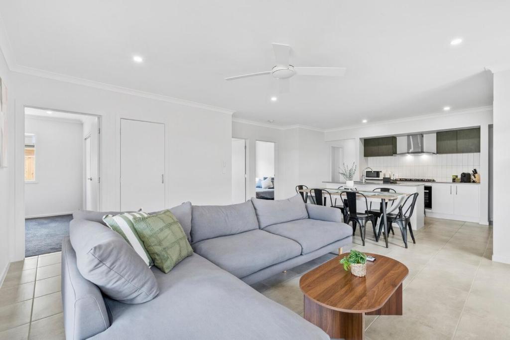 una sala de estar con un sofá y una mesa en Fresh and Stylish 4BR Getaway Near Local Parklands, en Marsden