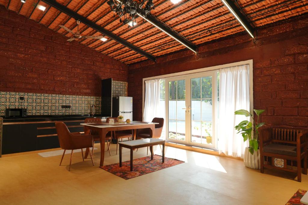 a kitchen with a table and chairs in a room at NOSSA GOA VILLA in MUMBAI GORAI in Mumbai