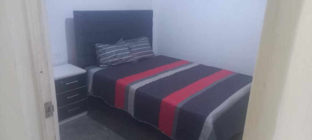 a small bedroom with a bed with a striped blanket at Hospedaje C y A in Lima
