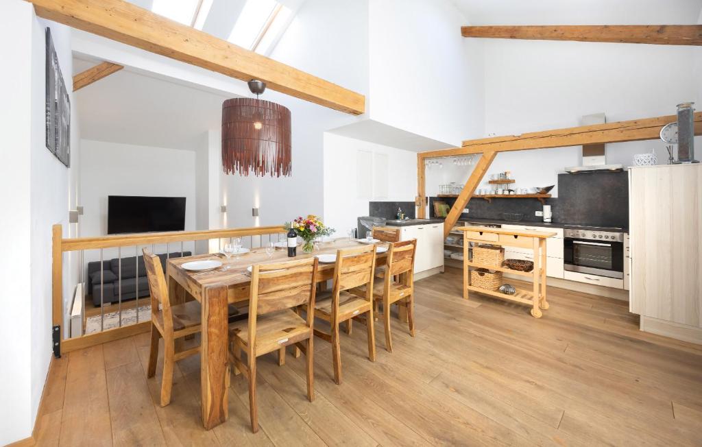 Una cocina con una mesa y sillas de madera. en GM-Stays Wendelstein Lodge, en Fischbachau