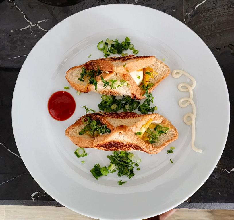 Un plato blanco con dos rebanadas de pan tostado con verduras. en Junction 14 Villa, en Dikwella North