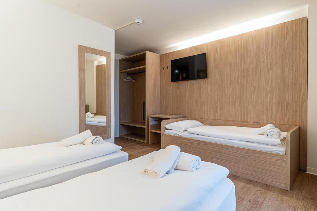 a hotel room with two beds and a tv at Hotel Bella Italia Piancavallo in Piancavallo
