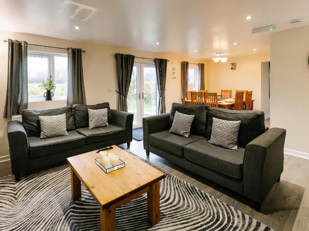 a living room with two couches and a table at Raven Lodge in Brigg