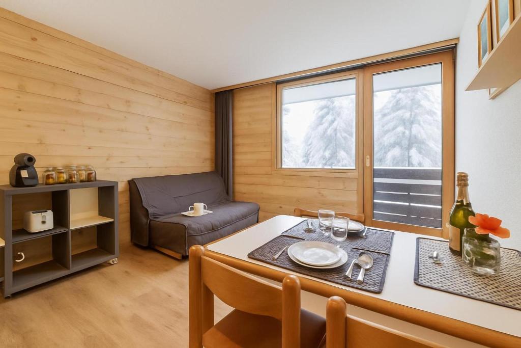 a living room with a table and a chair at Chamonix Sud - Grepon 102 - Happy Rentals in Chamonix-Mont-Blanc