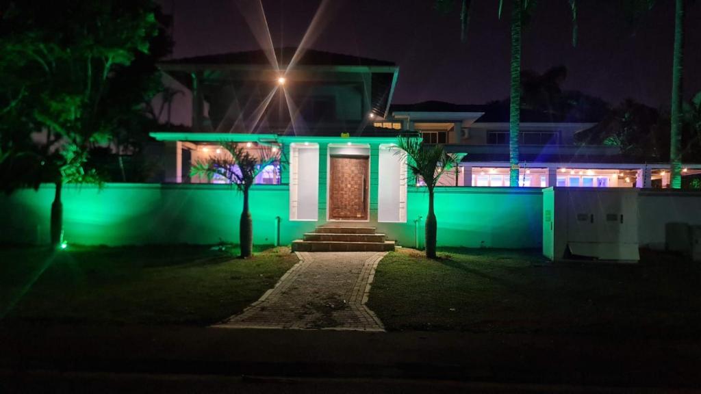 una casa iluminada por la noche con luces verdes en THE SEA BREEZE GUEST HOUSE & VENUE HIRE, 11 on SHELBOURNE, en Durban