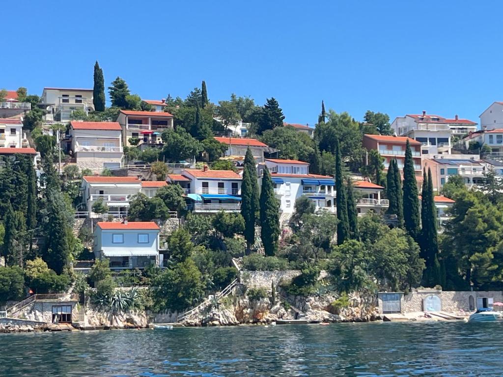 a group of houses on a hill next to the water at Apartment Gigi in Jadranovo