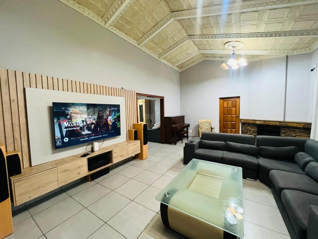 een woonkamer met een bank en een flatscreen-tv bij Chic 3-bed home with comfort in Pretoria