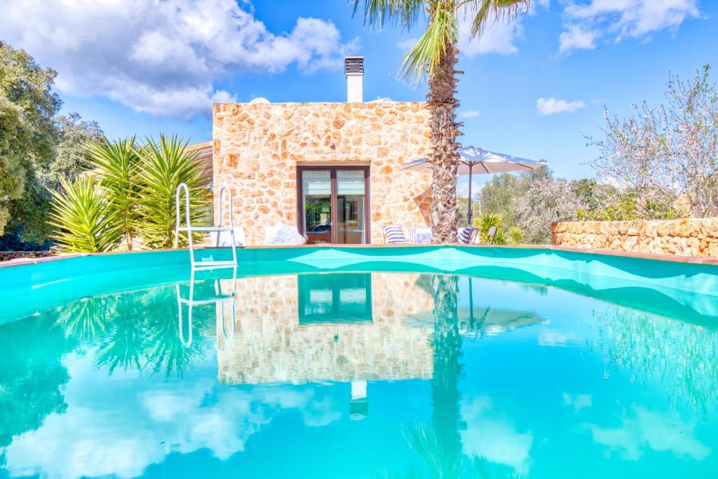 a villa with a swimming pool in front of a house at Finca Can Puput Bó in Son Gual