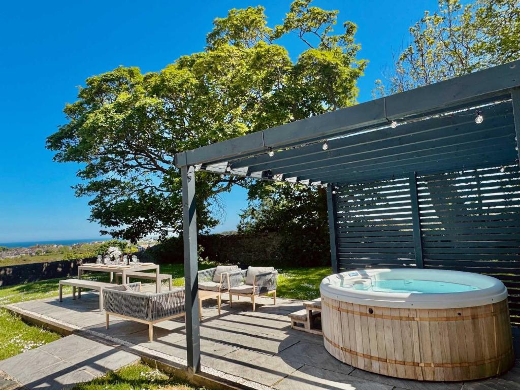 阿姆奇Luxury coastal retreat with sea views的天井设有热水浴池和凉亭