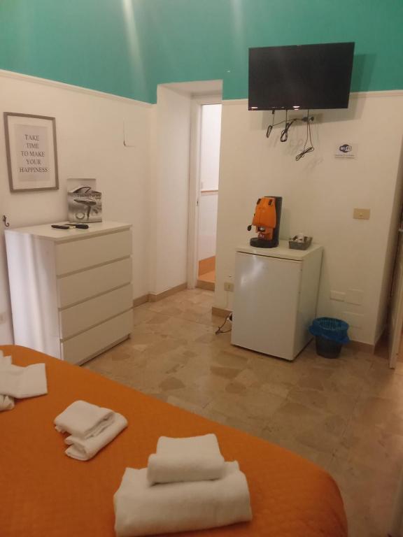 Habitación con 2 toallas en una mesa y TV. en Ulisse 1, en Nápoles