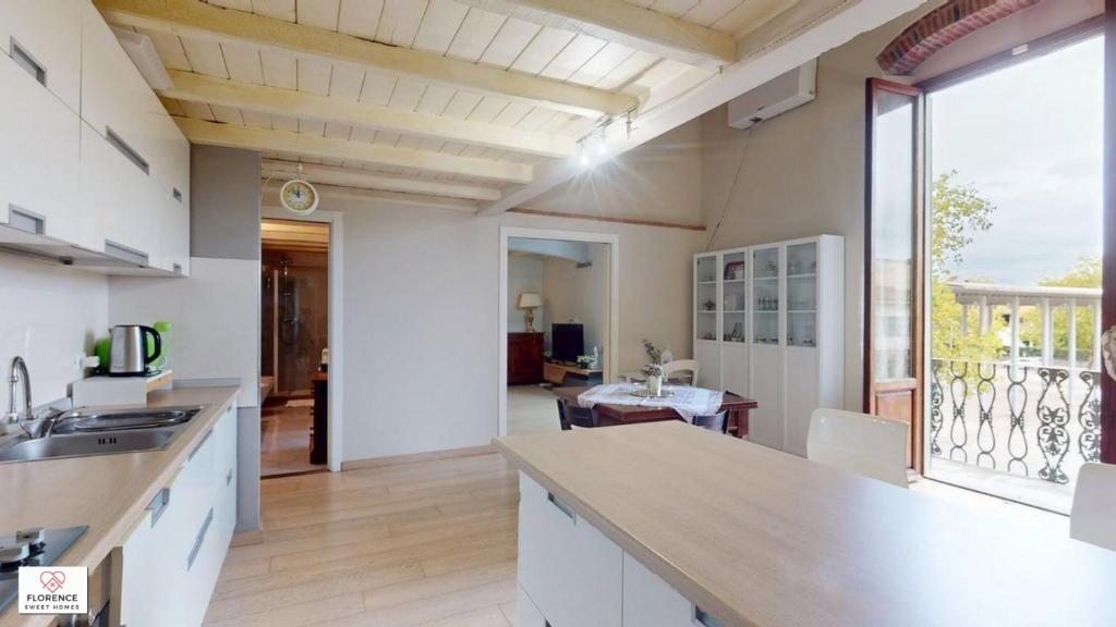 una cucina con mobili bianchi e una grande finestra di Loft Matteotti by Florence Sweet Homes a Scandicci