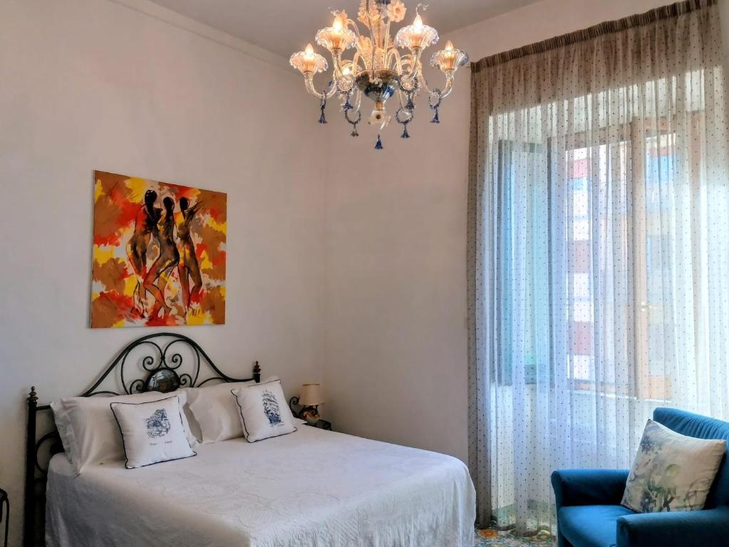 una camera con letto, lampadario a braccio e sedia di Room with a view a Salerno