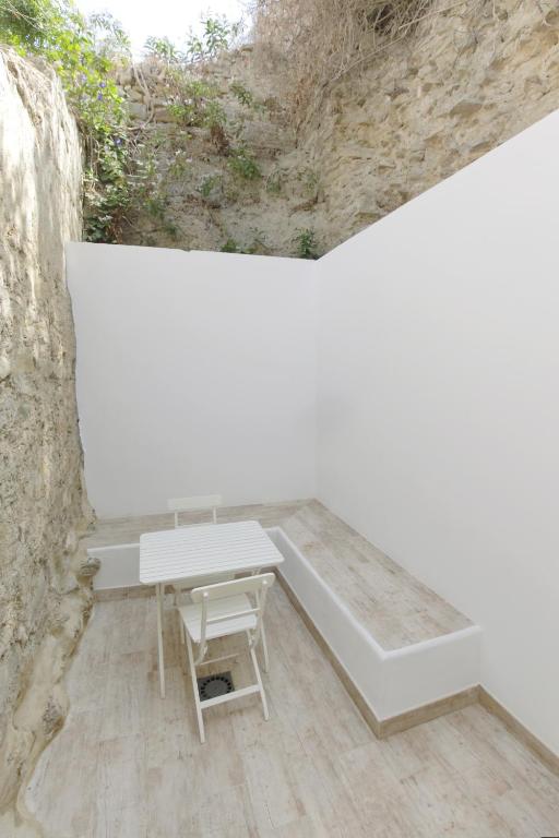 a white bench sitting next to a stone wall at Apartamentos Gravina in Tarifa